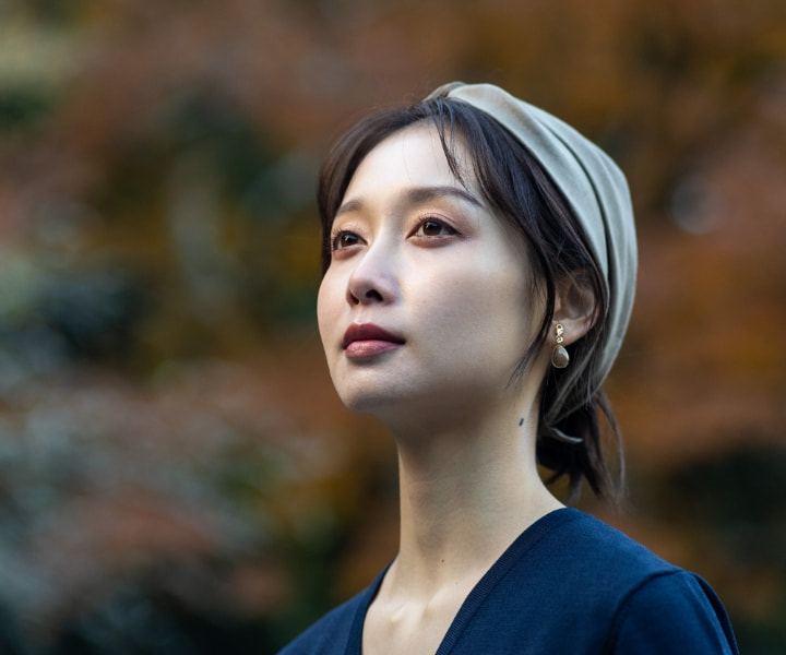 紅葉を背に佇む女性の横顔