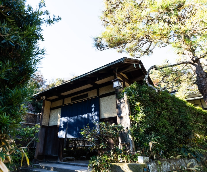 松に囲まれた「Sasho」の玄関。暖簾のかかる瓦葺きの門構え