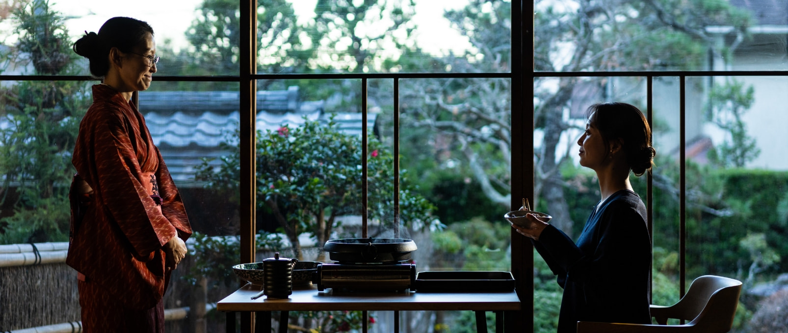 庭を望む窓辺の席で向かい合う二人