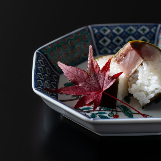 染付の八角皿に盛った鯖の押し寿司と紅葉のあしらい